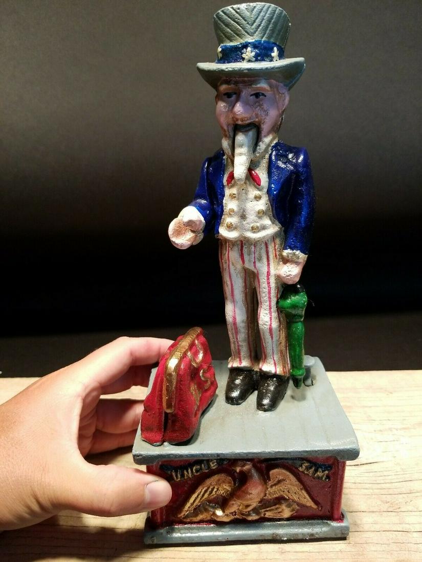 Uncle Sam Cast Iron Mechanical Coin Bank: 10 1/2" tall x 4 1/2" Wide Great reproduction folk art cast iron uncle sam coin bank. This piece was made to look just like an antique, but is actually a reproduction. Like the antiques you press the 