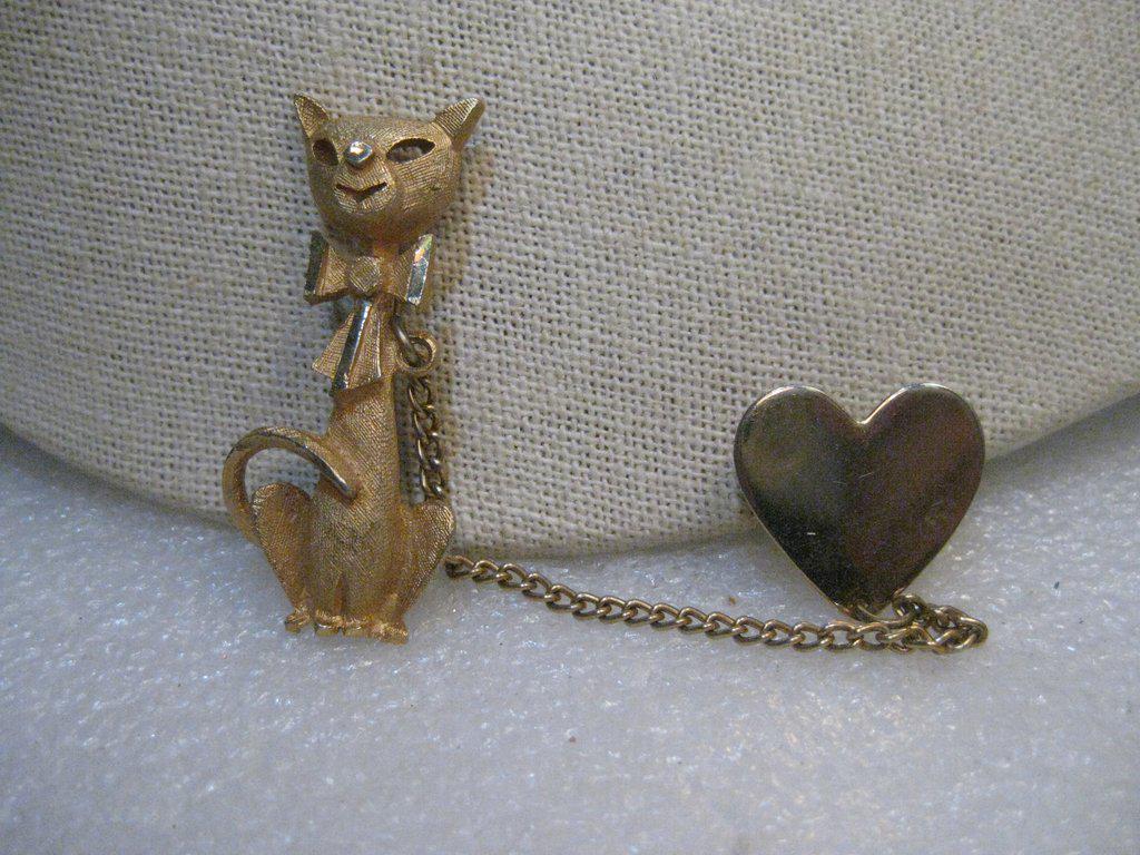 Vintage Siamese Cat and Heart Brooch/Sweater Guard,: Vintage Cat with Heart on Chain Brooch/Sweater Guard. 1960's with a Siamese tall sitting cat, modern design. It is 2" tall with a 3" curb link chain and a heart pin on the other end that is about 3/4"