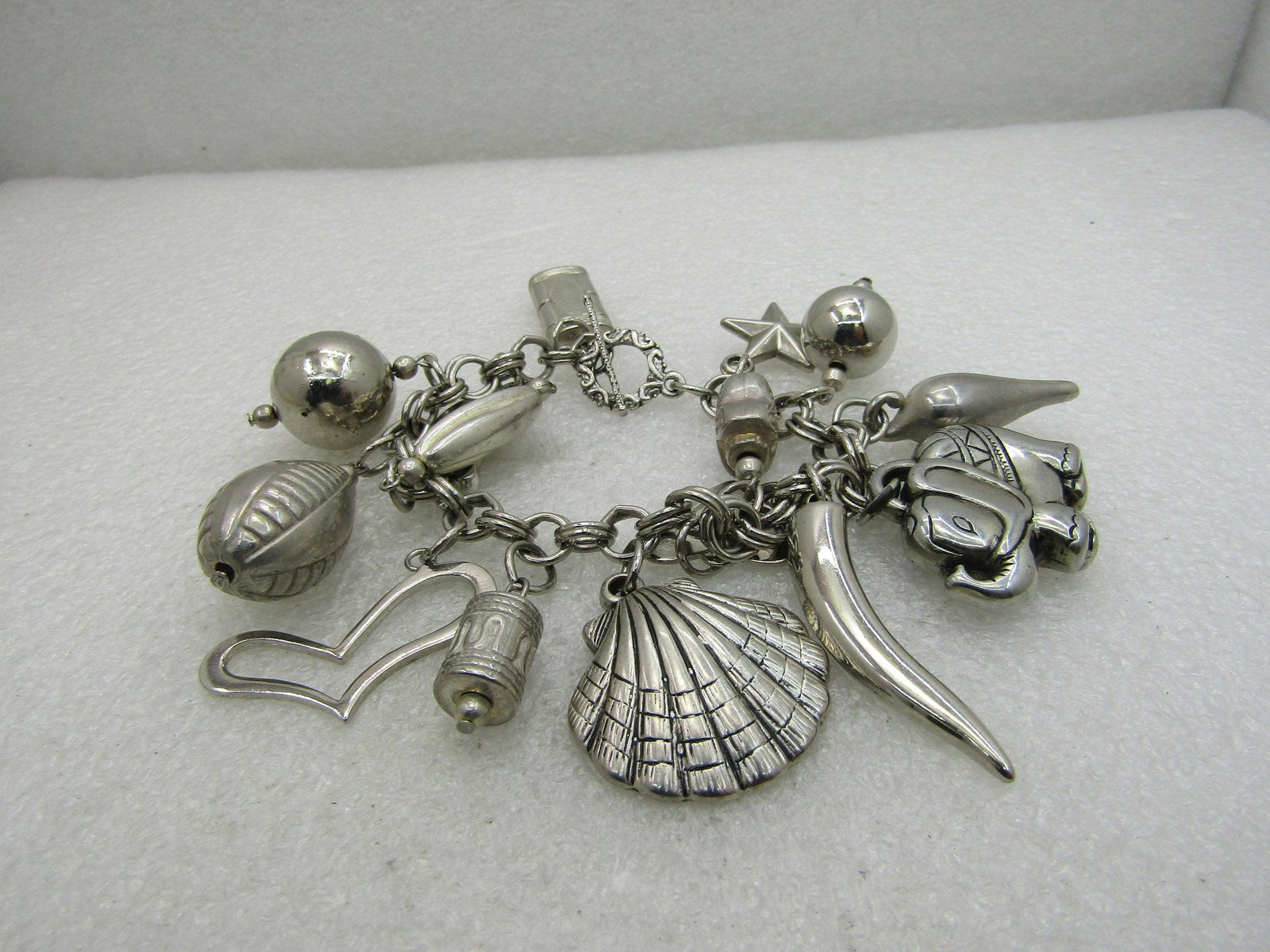 Vintage Mixed Genre Charm Bracelet, 7.5", Chunky,: Vintage Mixed Genre Charm Bracelet, 7.5", Chunky, Toggle Clasp. Silver tone with a mix of ethnic and cultural style charms from elephants to Bali beads, seashell, horns, stars, hearts and more. The ch