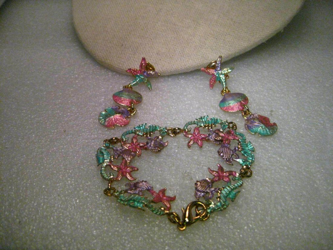 Gold tone Pastel Enameled Sea Life Bracelet & Dangle: Gold tone Metallic Pastel Enameled Seahorse, Starfish, Fish Bracelet and Dangle Clip Earrings. The bracelet is 8" long and the clip earrings have a starfish stud with a sand dollar and clam shell dang