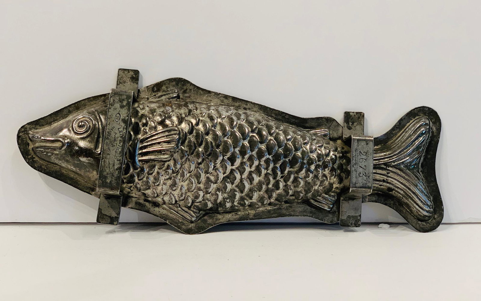 Handled ‘Flattie’ Fish Chocolate Mold, early 20th c: Title: Handled ‘Flattie’ Fish Chocolate Mold, early 20th c Description: Graphic, detailed scales, whimsical face. Signed LETANG FILS, PARIS. Dimension: 14 1/2” x 6” Circa: Early 20th c Shippin