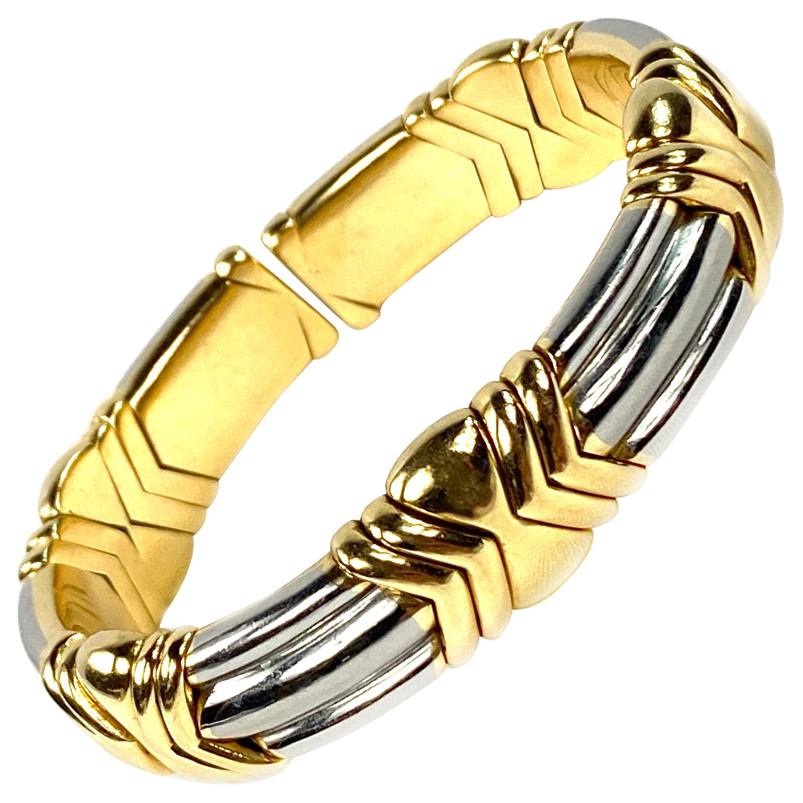 Bulgari Yellow and White Gold Cuff Bangle Bracelet: Featuring flexible cuff bangle with 18K yellow gold geometric links and stainless steel ribbed links. Signed BVLGARI, stamped 750, serial number is 7589. Measurement: diameter is 3", the width is 0.5"