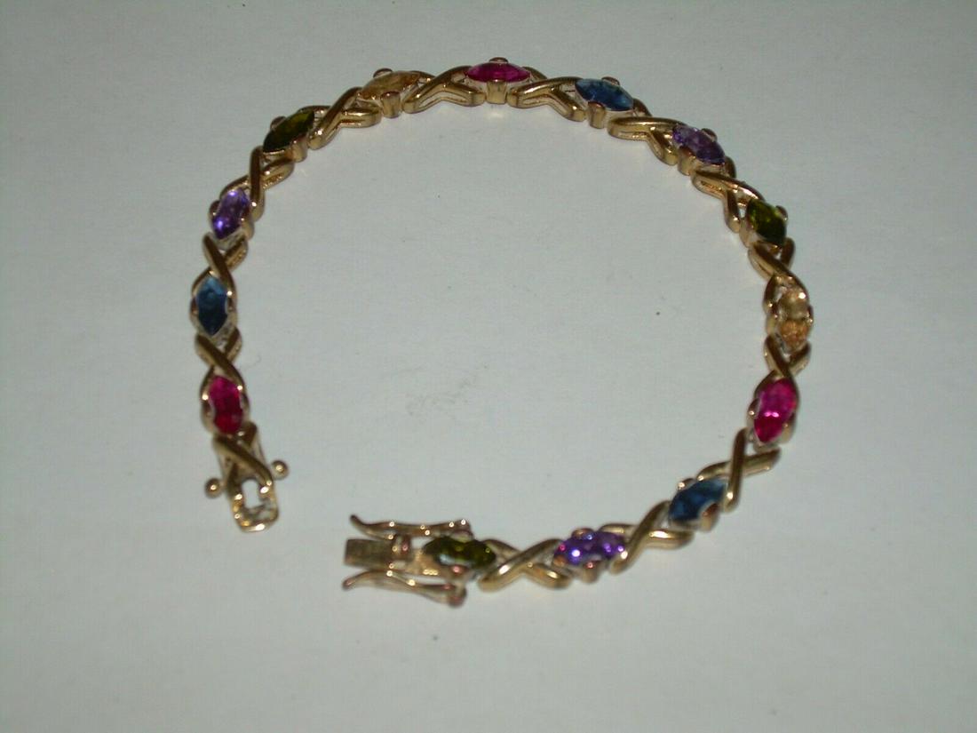 Faux Gem Stone Tennis Bracelet - Vintage Gold Tone: Vintage faux gem stone tennis bracelet. There are a mixture of amethyst, sapphire, blue topaz, ruby, citrine, and an onyx. The bracelet comes in gold tone and is 7" in length. The bracelet has a safet