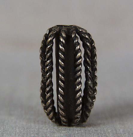 19c bronze OJIME netsuke slide: 19th century bronze ojime (slide bead for tightening the cord going from netsuke to inro) of seed shape with solid central tube and ribs made of twisted wire. Nice work, pleasant feel of age, beautifu