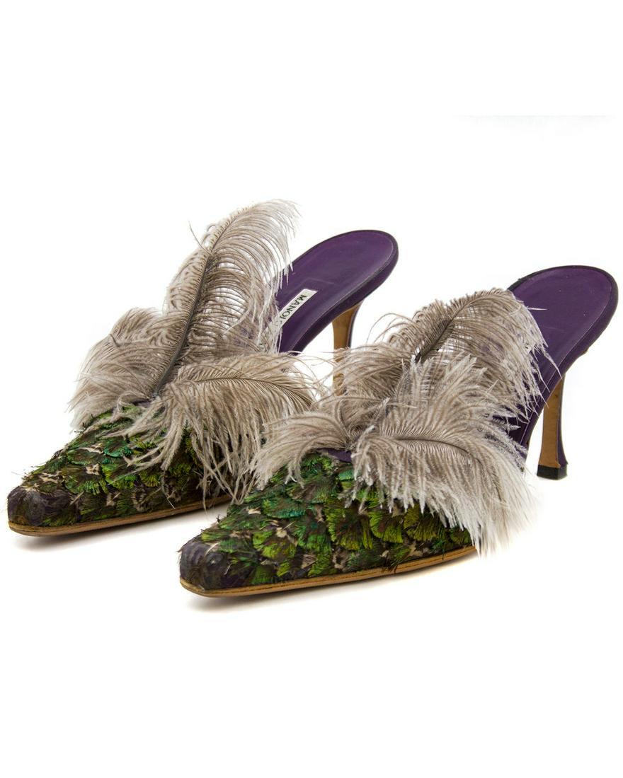 Manolo Blahnik Feathered Mules: Birds of a feather! These Manolo Blahnik high heeled mules look like a pair of exotic birds for your feet. The pointed toe box is covered in iridescent green and purple feathers in an overlapping form