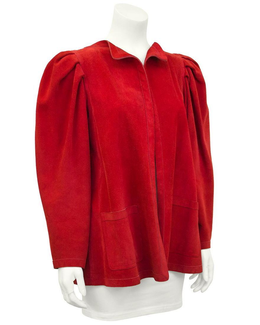Jean Muir Red Suede Jacket: 1980s red suede Jean Muir swing jacket. Large ruched shoulders, lays flat on body with no buttons, flat patch pockets at hips and pleat at back centre seam. Unlined. Excellent vintage condition. Will 