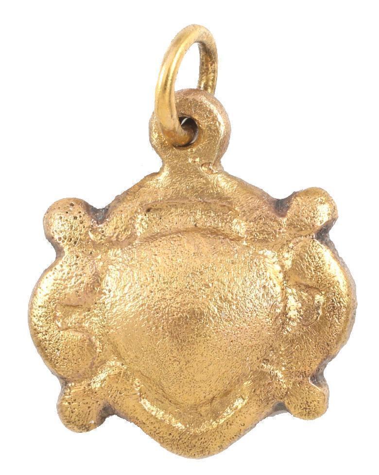 ANCIENT VIKING HEART PENDANT NECKLACE C.1000 AD: A good example in its fully evolved form. Flat embellished in deep relief with a centered naturalistic heart surrounded by reverse curves forming the quartered nubs. Just under 7/8” height, made by 