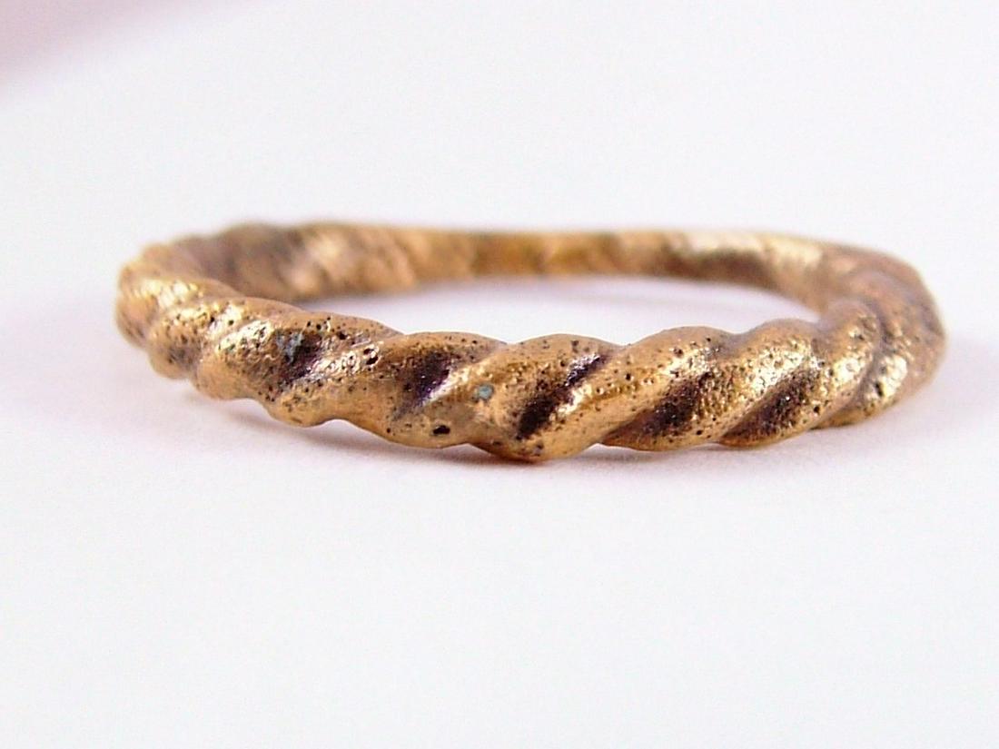 VIKING ROPED OR TWIST WEDDING RING SIZE 6 ½: Cambridgeshire, England, 866-1067 AD. Oval form, size 6 ½. 1.7mm at the bottom swelling to 2.8mm at the top. The top 2/3 is a deeply modeled roped motif. The spiral or helix was a favorite Viking for