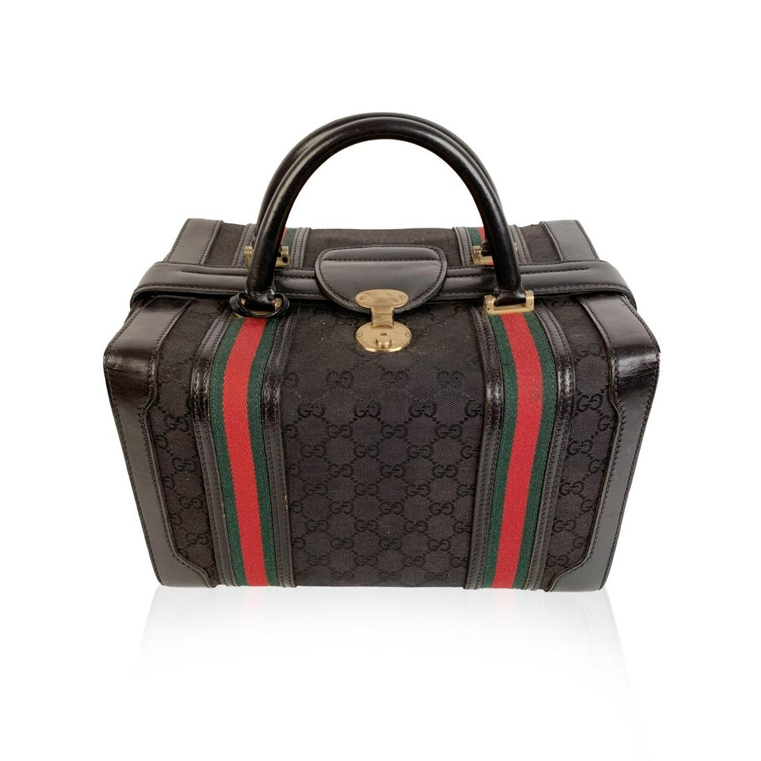 Gucci Vintage Black Monogram Canvas Train Case Beauty: Splendid vintage train case by GUCCI from the early 1970s. Crafted in black monogram canvas with black genuine leather trim and handles. It features double green/red/green striped detailing and gold-t