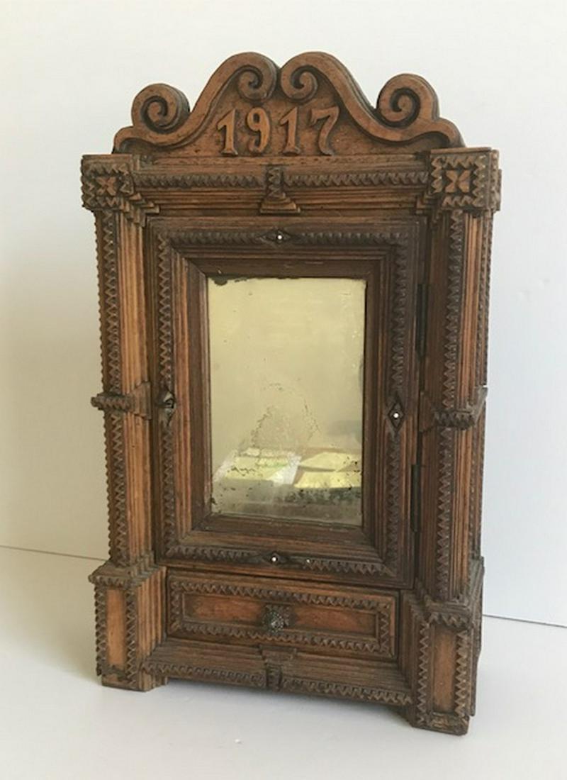 Tramp Art Shaving Cabinet 1917: Title: Tramp Art Shaving Cabinet 1917 Provenance/Additional Info: Early 20th century carved and notched shaving cabinet made from packing crate wood. This was made for traveling with a locking, mirror