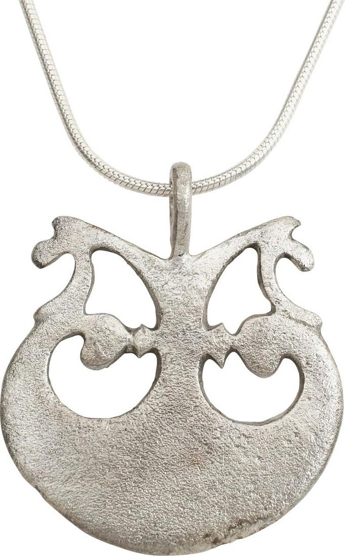 VIKING ASTROLOGICAL AMULET NECKLACE, 9th-10th CENTURY: Silvered bronze, 1 ¼” height. The crescent moon with expanded terminals representing Sol the sun and Mani the moon. The center with a complex symmetrical form with angular connectors to the Sol and