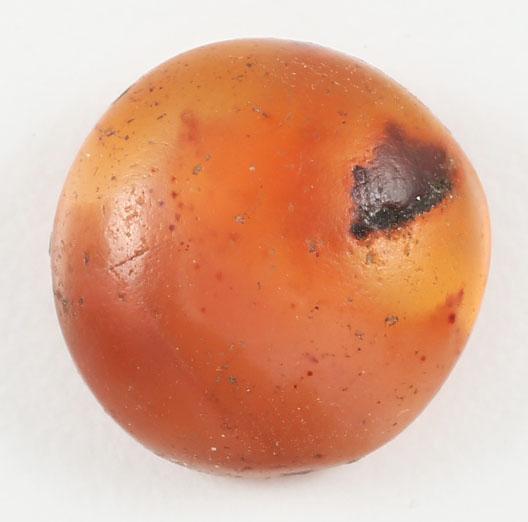 ANCIENT VIKING GEM STONE 8-11TH CENTURY AD: Polished carnelian, oval, 11.7-12.0mm, flat back cabochon. 5.3mm thick. Nicely mottled gray t amber with a black spot for which it was selected and which undoubtedly was deemed to have mystical powers