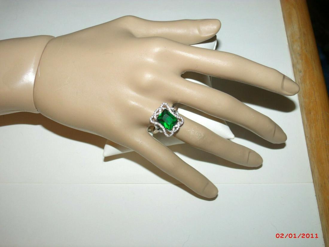 Sterling Faux Emerald Cocktail Ring - CZ/Crystal Size: Vintage sterling silver ring is a faux emerald cocktail ring. The stone is an emerald cut. The stone is prong set and accented by an open CZ weave. The CZ/Crystal emerald is 10mm x 8mm. The ring is a