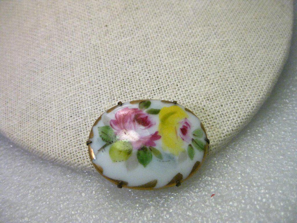 True Victorian Hand Painted Triple Rose Porcelain: True Vintage Victorian Hand Painted Triple Rose floral oval porcelain brooch with gold trim. It is 1.5" wide and slightly over 1" tall. It has a gold tone backing with the pin that extends almost to t