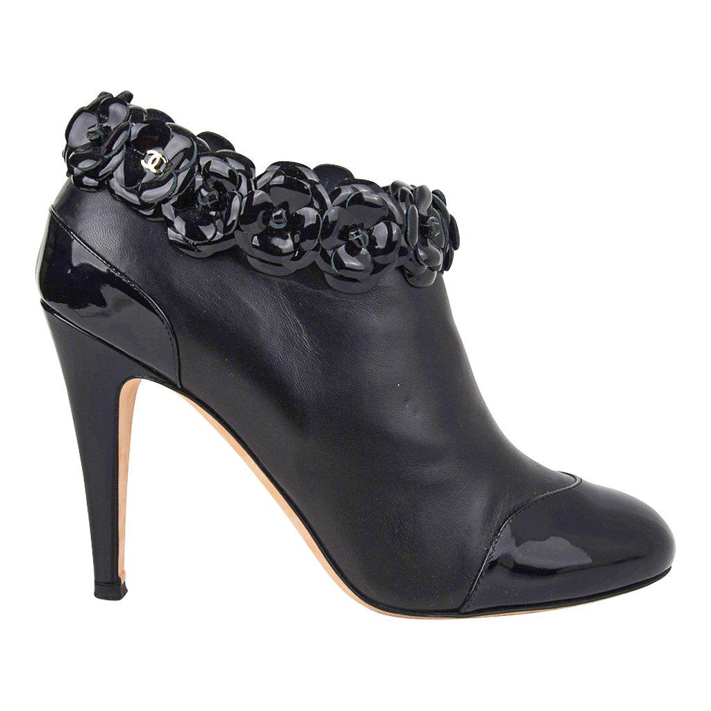 Chanel Ankle Boots Black Patent / Leather Camellia: Guaranteed authentic Chanel black ankle boots with patent leather heel and toe cap. Black patent leather signature Camelia flowers edge. Zipper on inside of foot. So chic. final sale SIZE 40 USA SIZE 