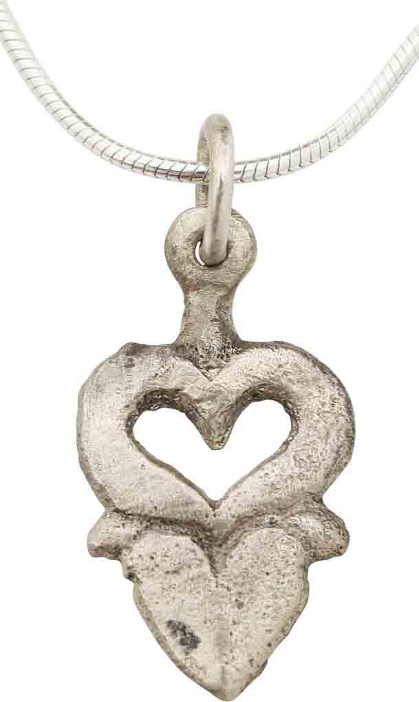 EXTRAORDINARY VIKING HEART PENDANT NECKLACE 850-1050 AD: Very fine example in its fully evolved form. 0.85” height. Of overall heart form with cusped top, and actually comprised of two individual hearts The upper as a broad bordered pierced heart above a 