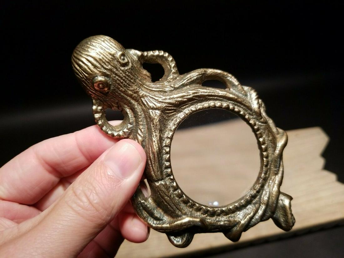 Brass Octopus Magnifying Paperweight Hand Lens: 5 3/8" Long x 3 3/8" Wide Such a neat reproduction antique brass octopus magnifying glass. The Magnifying glass has a glass lens and a cast brass frame. The magnification Reserve: $25.00 Shipping: Dom
