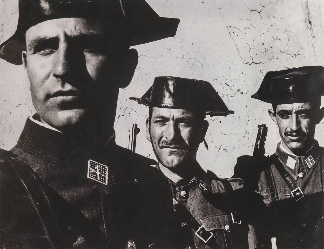 W. EUGENE SMITH - Spanish Civil Guard, 1950: Artist: W. EUGENE SMITH Title: Spanish Civil Guard, 1950 Medium: Photo Litho, 1995, USA Dimensions: 7.5x5.75" Description: Heat Wax Mounted on 8.5x11" Conservation Board The Story: This wide-angle por