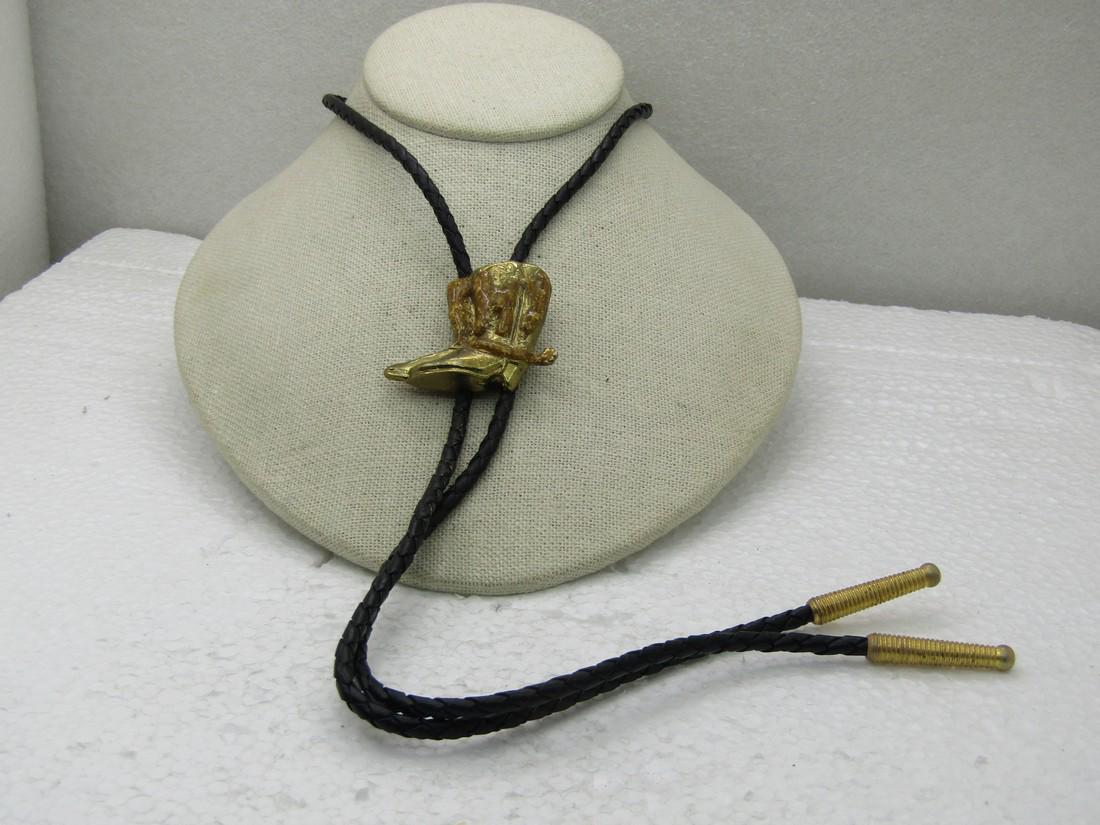 Vintage Southwestern Muddy Boots Bolo Tie, 36", Gold: Vintage Southwestern Muddy Boots Bolo Tie, 36", Gold Tone, 1960's-1970's, 36" black braided leather tie with gold tone ridged end caps and gold tone 1.5" boots with a brown lumpy coating that looks li
