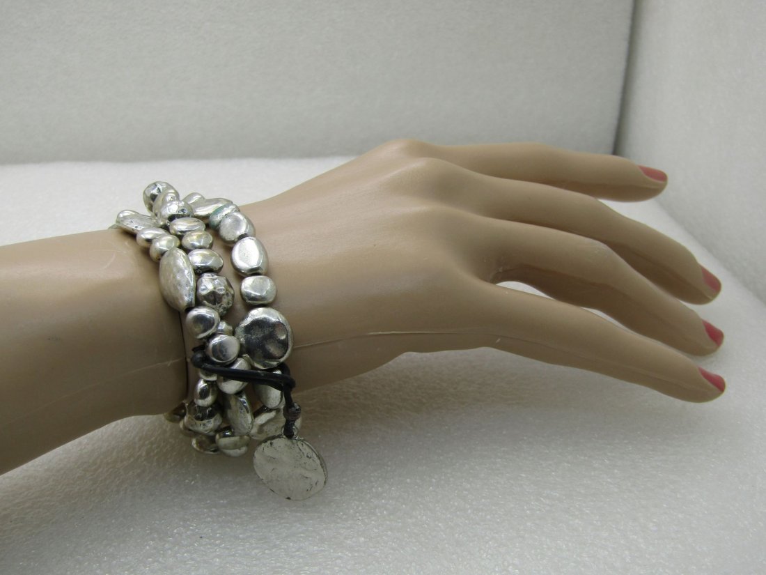 Three Silver Tone Nugget Stretch Bracelets with: Three Silver Tone Nugget Stretch Bracelets with Loop/Charm Accent, 7.5".ÿ These are hammered and nugget like silver tone beads that are 1/4" to slightly over 1/2" wide and various natural types of sh