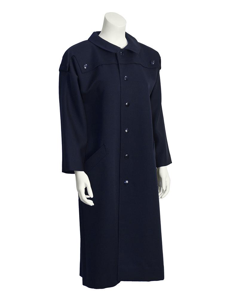 Pierre Cardin Navy Trench Coat: This Pierre Cardin trench coat from the 1970's features a Peter Pan style rounded collar, a storm flap attached with buttons, front button closure and two broad welt side pockets. Snap buttons are nav