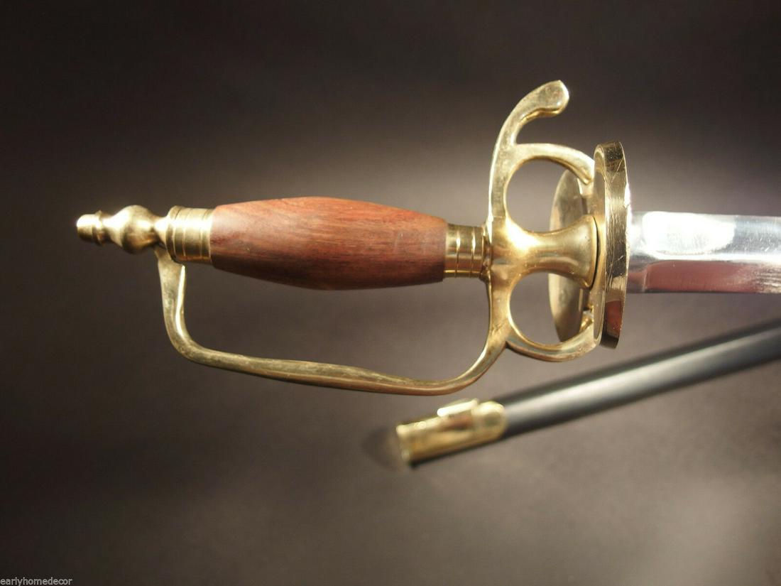 French Hanger Cutlass Sword Brass Wood French Indian: 43" Long with scabbard 38" overall 30 1/2" V blade 4" Wood handle Similar to the replica Antique English Hanger we offer, this piece is the French Hanger Replica c1730-1750 wood handle, solid brass so
