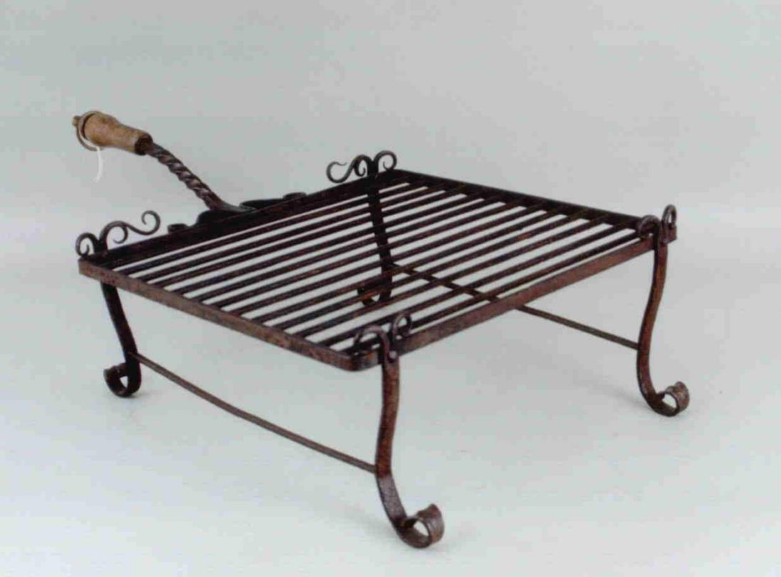A finely detailed wrought iron grill with wood handle (1 of 1)