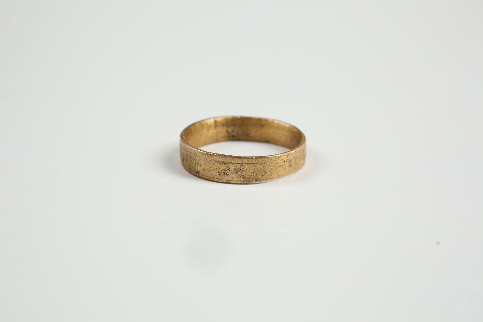 FINE VIKING WEDDING RING, 850-1050 AD, SZ 7 ¾: Gilt bronze, size 7 ¾, 4.4mm width. Flat band decorated with alternate sunbursts and clusters of three ciphers (runes?) in uneven spacing suggesting a supernatural significance. Professionally refurb