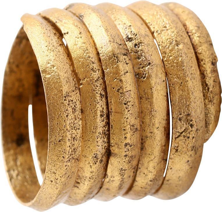 FINE VIKING COIL RING, 10th CENTURY AD SIZE 9 ¼-9 ½: Gilt bronze. Size 9 ¼-9 ½. Medially ridged rounded face band in 4 1/4 coils to over 5/8” width. Lightly textured from burial. Sound wearable condition and professionally refurbished with the 24kar