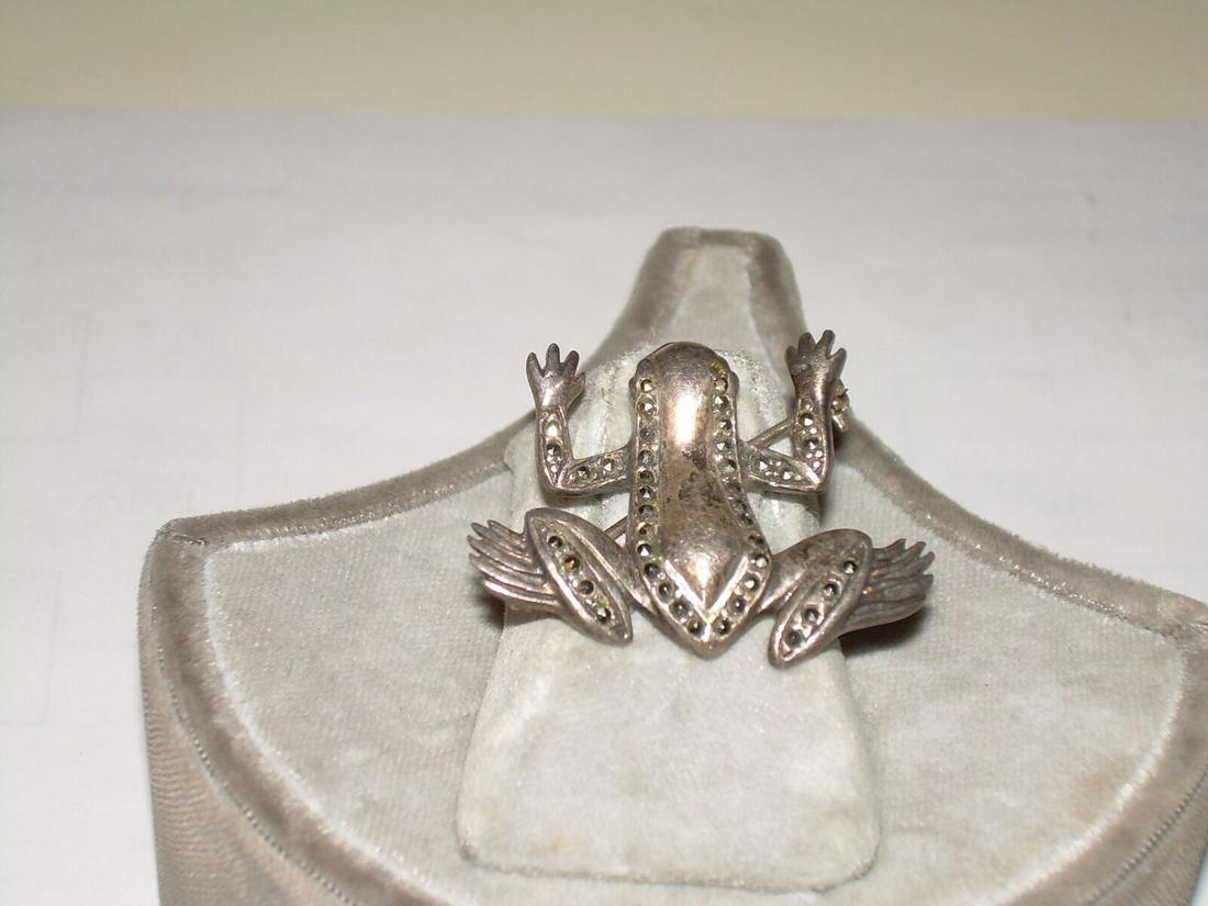 Vintage sterling silver brooch was purchased at an: Vintage sterling silver brooch was purchased at an estate sale. The brooch depicts a leaping frog. The pin has accents of marcasite throughout. The pin measures 1.25" wide and 1" in length. The clasp 