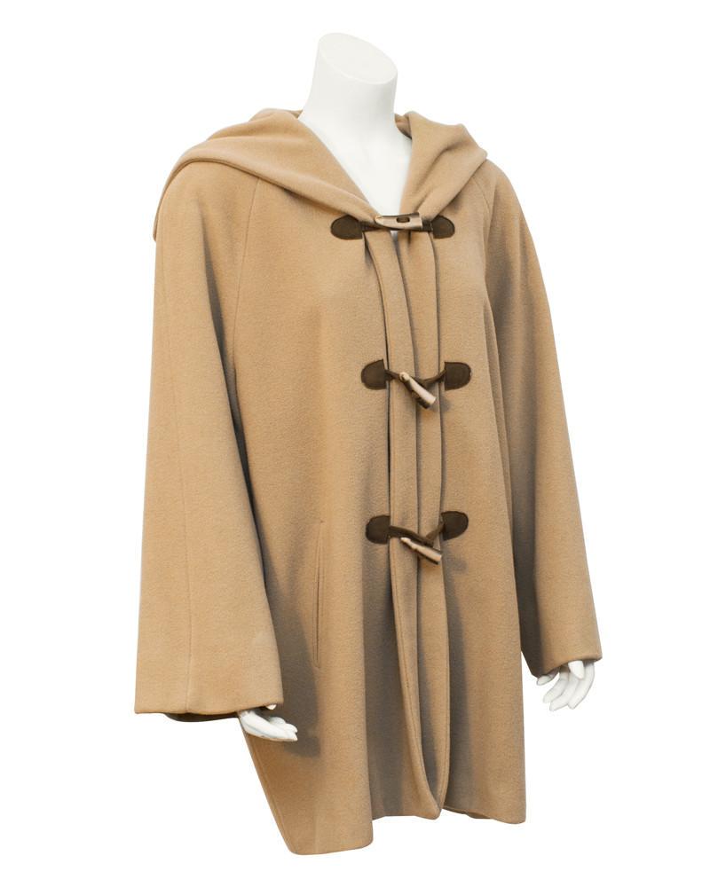 Giorgio Armani Tan toggle swing coat: Title: Giorgio Armani Tan toggle swing coat Additional Information: Cozy camel Armani coat from the 1980s, the swing shape is forgiving and fun. Closes with three faux horn and brown leather toggles a
