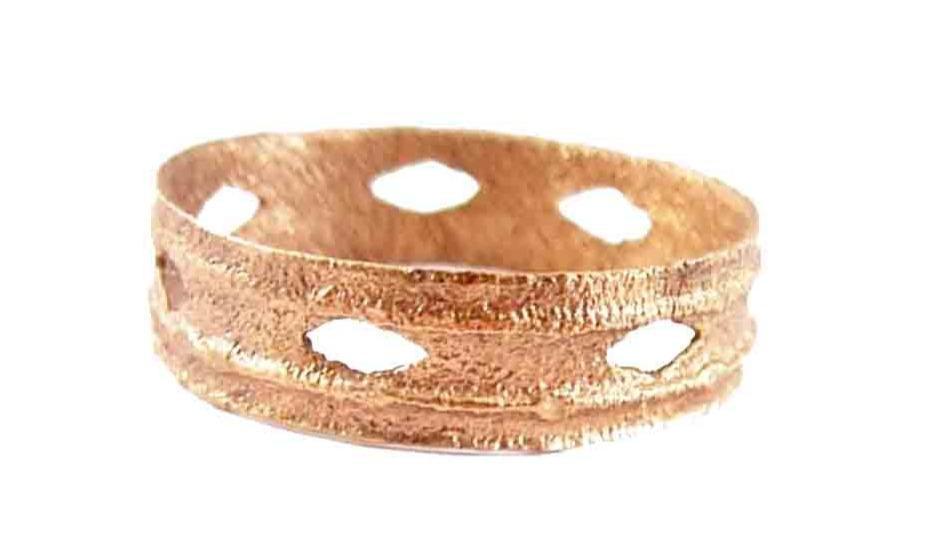 RARE VIKING BEARD RING, 10th-11th CENTURY AD: Gilt bronze. Broadband, 4.6mm. Both edges with raised edge depressed center band. The medial with 7 rounded diamond piercings. 0.61" 15.6mm inside dimension. The use of beard rings by Viking warriors 
