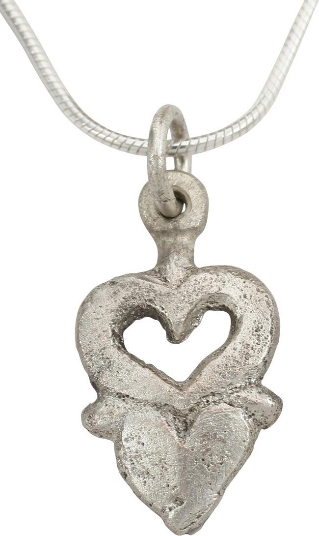EXTRAORDINARY VIKING HEART NECKLACE 850-1050 AD: Very fine example in its fully evolved form. 0.82" height. Of overall heart form with cusped top, and actually comprised of two individual hearts The upper as a broad bordered pierced heart above a si