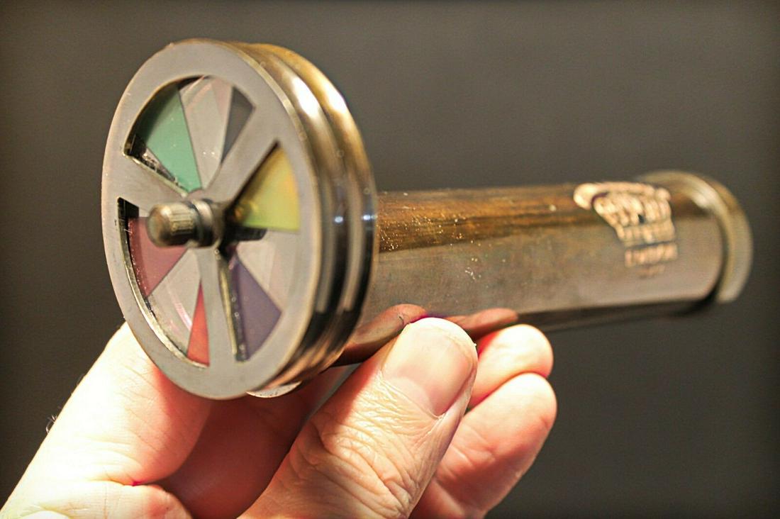 Brass Kaleidoscope "London 1917" Toy: 6" Long x 2 1/8" Wide Nice quality brass reproduction antique kaleidoscope. This piece is all brass and works by turning the color wheel while viewing the changing colors through the eye piece. Such a