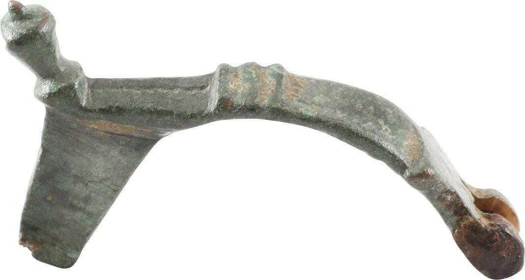 ANCIENT ROMAN FIBULA 1ST C. BC-1ST C. AD: No Reserve! Bronze, just over 1 3/4” in length, the elegant form is known as a bow fibula. Probably for a woman’s garment. Broad frame with arched back with transverse crests. Stepped nob 
