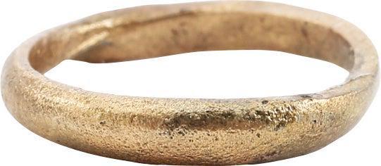 ANCIENT VIKING WEDDING RING, SIZE 5 ½: Late 9th-early 11th century AD. Gilt bronze, size 5 1/2. Medium band 3.3mm, with a rounded face. the sides of tapering thickness, perhaps emulating the coil form popular with Vikings. Surface textured