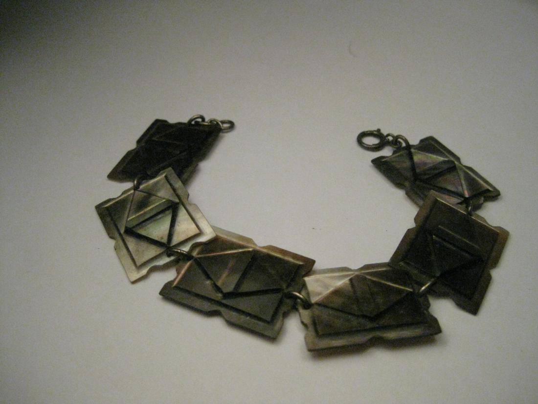 Vintage Sterling Silver Carved Mother-of-Pearl/Abalone: Vintage Bracelet, Art Deco Sterling Silver Carved Mother of Pearl Tile Bracelet. It is 7" long an 3/4 wide. The connecting pieces and clasp are made of sterling silver. This appear to be a unique piec