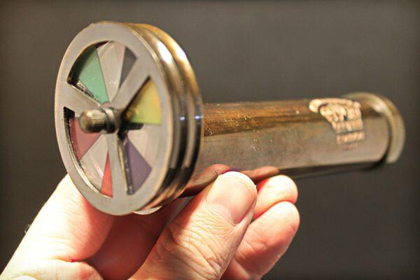Brass Kaleidoscope "London 1917" Toy: 6" Long x 2 1/8" Wide Nice quality brass reproduction antique kaleidoscope. This piece is all brass and works by turning the color wheel while viewing the changing colors through the eye piece. Such a