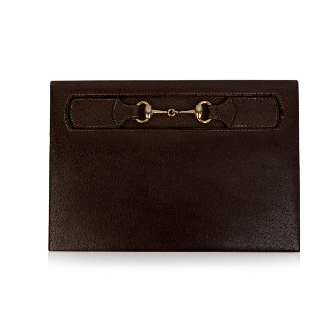 Gucci Vintage Brown Leather Horsebit Desk Notebook: Gucci Vintage Horizontal Desk Notepad. Crafted in brown leather with gold metal horsebit detailing. 'Made in Italy by GUCCI' embossed on the bottom of the notepad. 1 slot for notebook internally. Meas