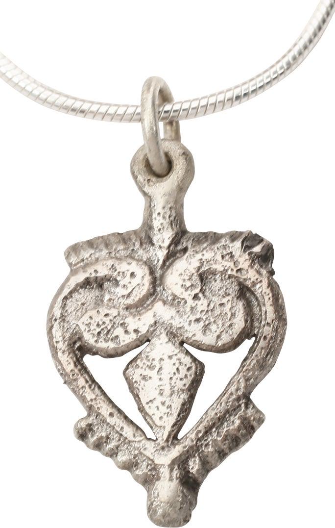EXTRAORDINARY VIKING HEART NECKLACE C.850-1050 AD: Very fine example in its fully evolved form. 03/4” height. Fully evolved heart form with the sides scrolling at the top and forming the cusp. The field with a trefoil, with the bottom piercing. 