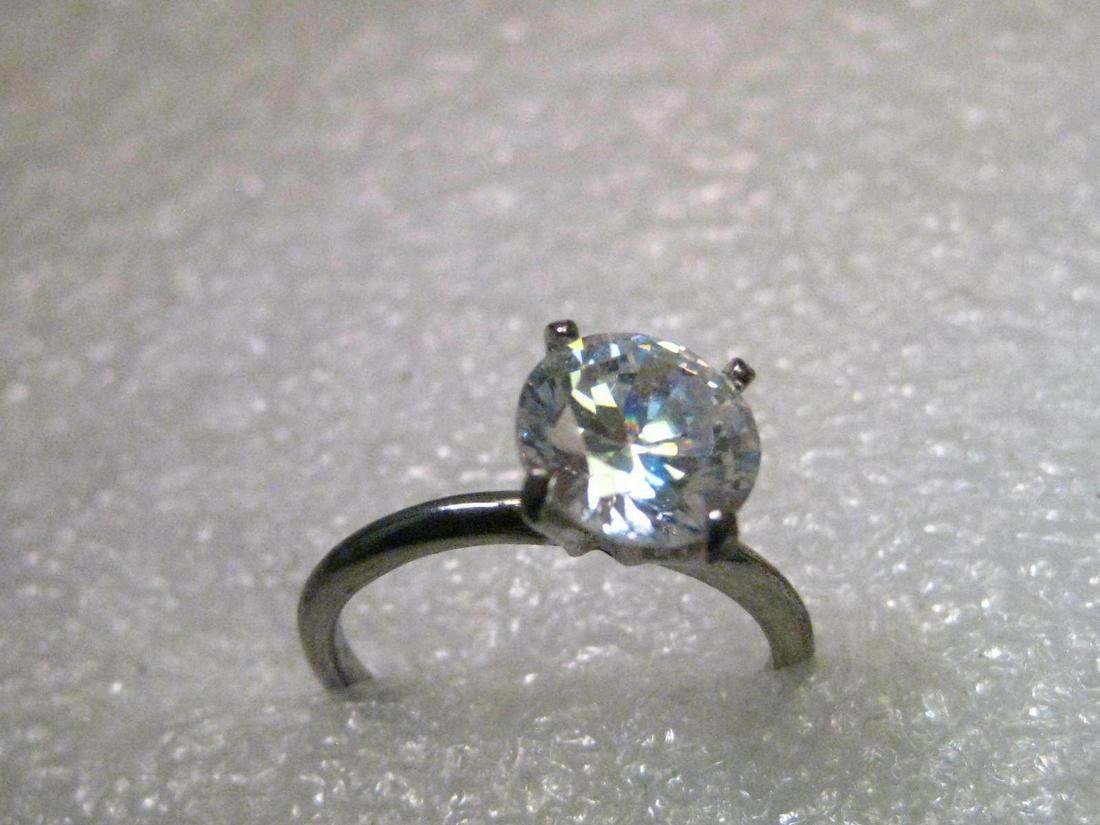 Vintage Silver Tone 7mm Clear CZ/Rhinestone Engagement: Vintage 7mm Faux Diamond Engagement Ring, size 7, Solitaire High Prong-Set stone. The faux diamond is clear and either rhinestone, crystal, or possibly CZ. It is signed inside the band with an A with 