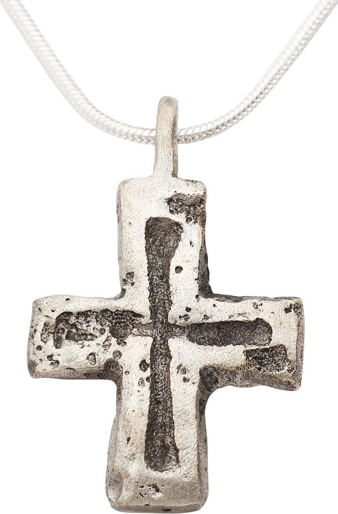 MEDIEVAL PILGRIM’S RELIQUARY CROSS NECKLACE: 7th-10th Century AD. Silvered bronze, 1 1/8” height. Centered cross beam. Both beams with slightly flared ends and incised medials. The back recessed for the inclusion of a holy relic Carried by Eur