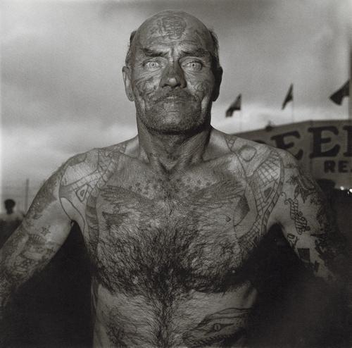 DIANE ARBUS - Tattooed Man at a Carnival, MD, 1970: Artist: DIANE ARBUS Title: Tattooed Man at a Carnival, MD, 1970 Medium: Photo Litho, 1972, USA Dimensions: 8.3x.8.2" Description: Heat Wax Mounted on 11x14" Conservation Board Artist Bio: Diane Arbus 