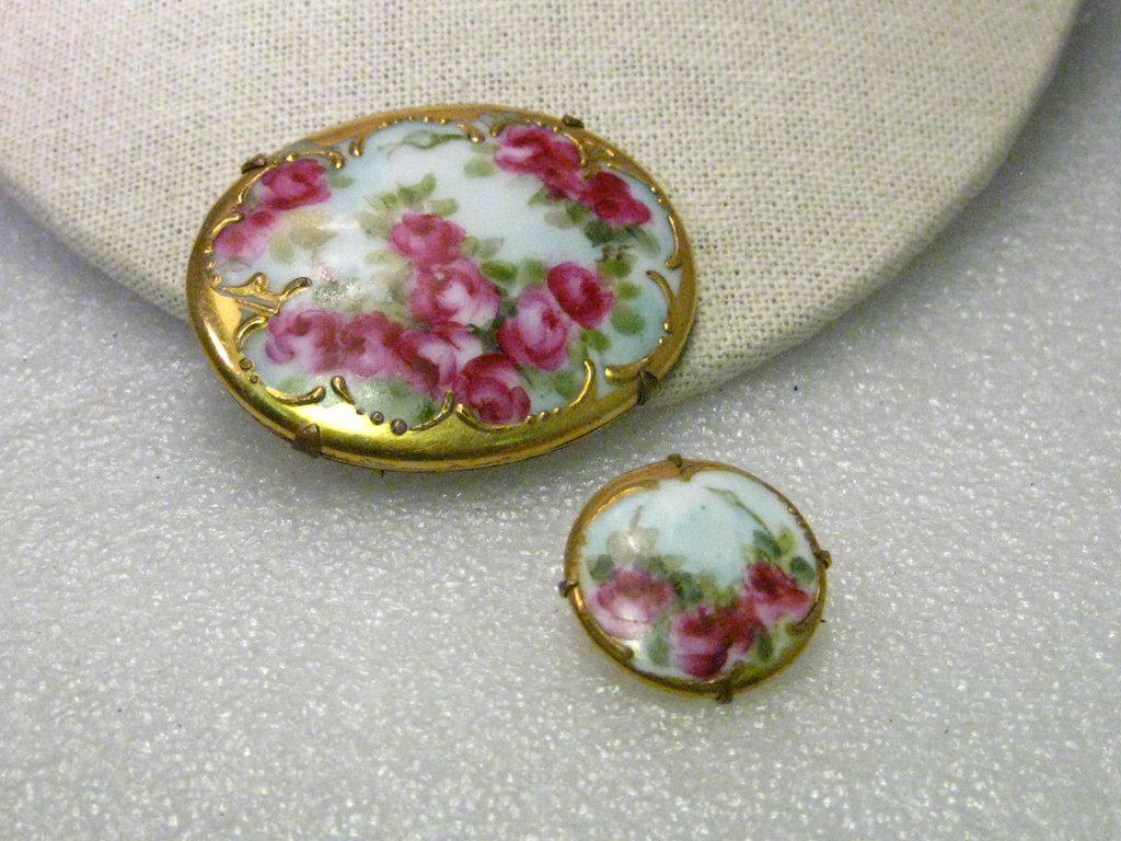 True Victorian Pair of Hand Painted Gold Trimmed Rose: True Vintage Pair of Victorian Hand Painted Shades of Pink with green leaves rose floral oval porcelain brooch that is 2" by 1.75" and a 1" matching circle brooch. It has a gold tone backing with the