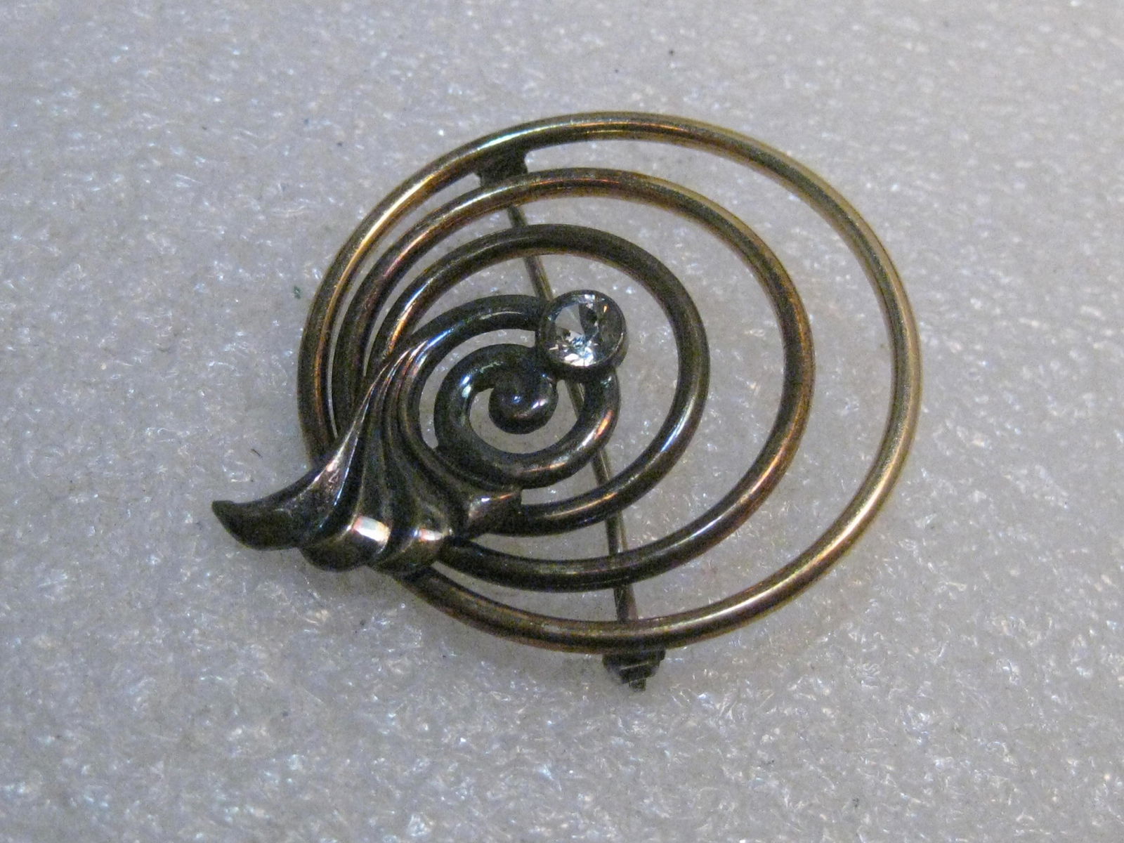 Vintage Symmetalic Sterling Brooch, Art Deco with Blue: Vintage Symmetalic Art Deco Brooch - 1/20th 14kt gold overlay - it has a series of concentric circles with a flared end and a round bezel set 4mm pale blue glass rhinestone. 1940's. Weight is 10.27gra