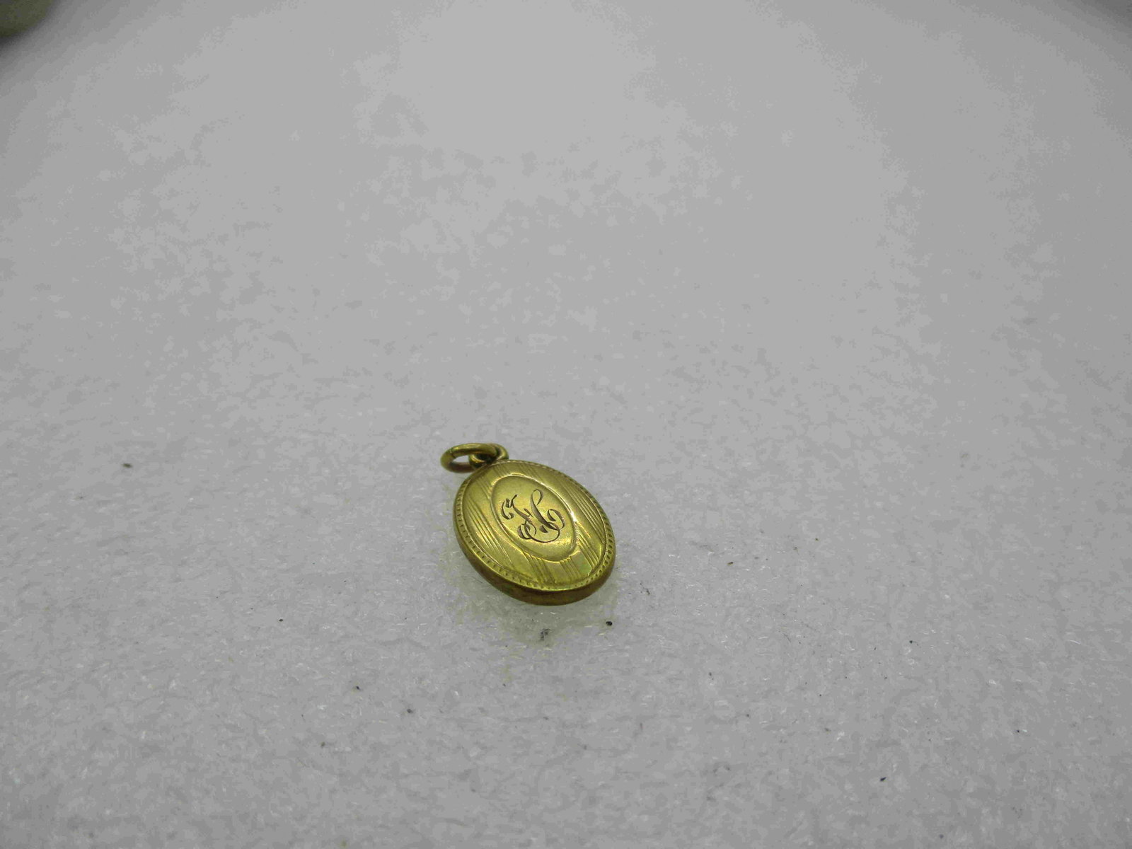 Vintage 10kt Initial H Pendant, 12-25-22 Dated, 7/8": Vintage 10kt Initial H Pendant, 12-25-22 Dated, 7/8" Oval , Ridged lines with a center oval and the initial engraved in the center It looks like an H. Weight is appx. .67 gr. 1920's, marked 10kt and t