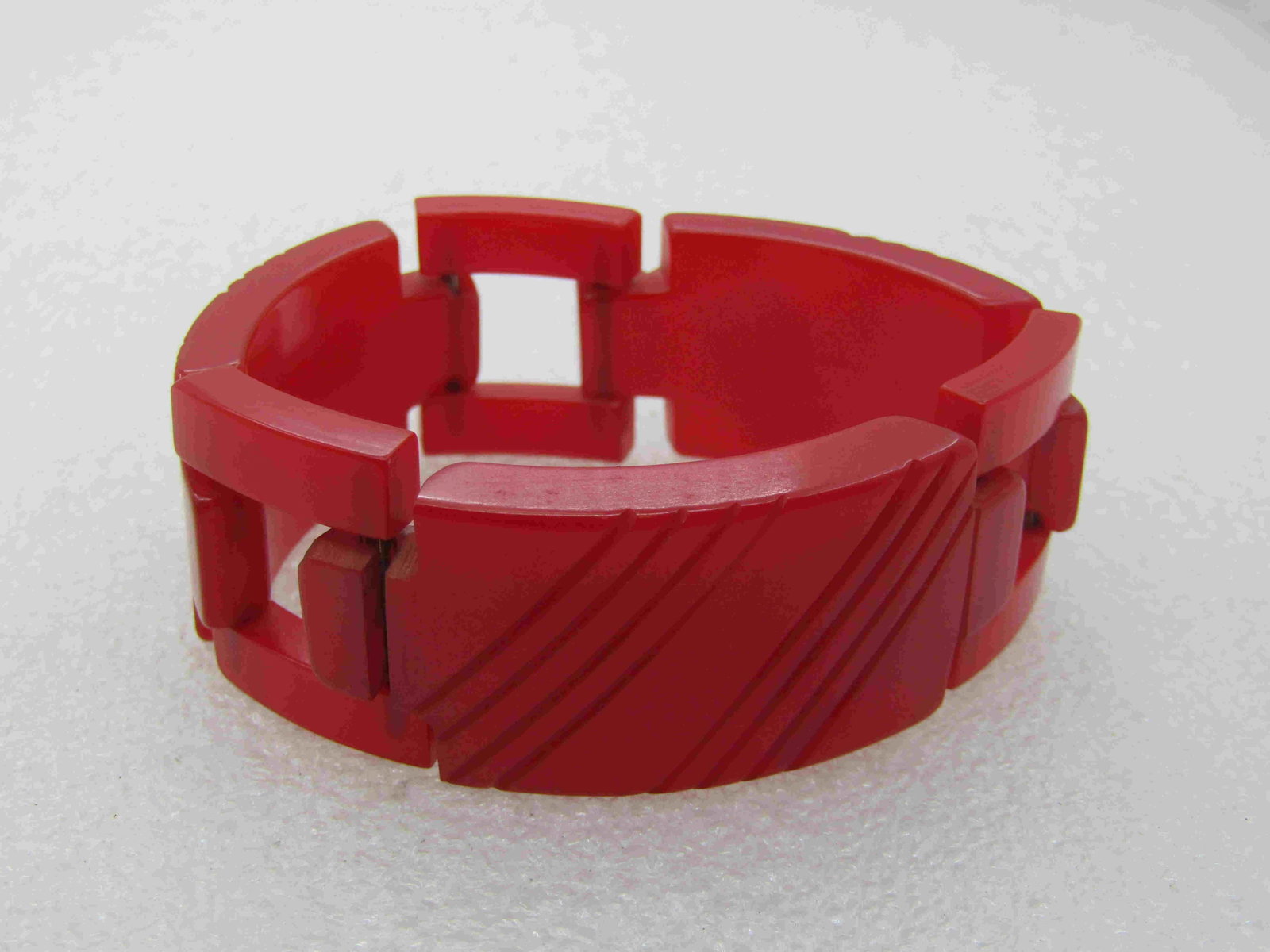 Vintage Red Bakelite Link Bracelet, Hidden Clasp 7",: Vintage Red Bakelite Link Bracelet, Hidden Clasp 7" long and 1" tall. Carved diagonal linkes in the sold curved links with square connector links. The clasp has a bar that easily slides to open and cl