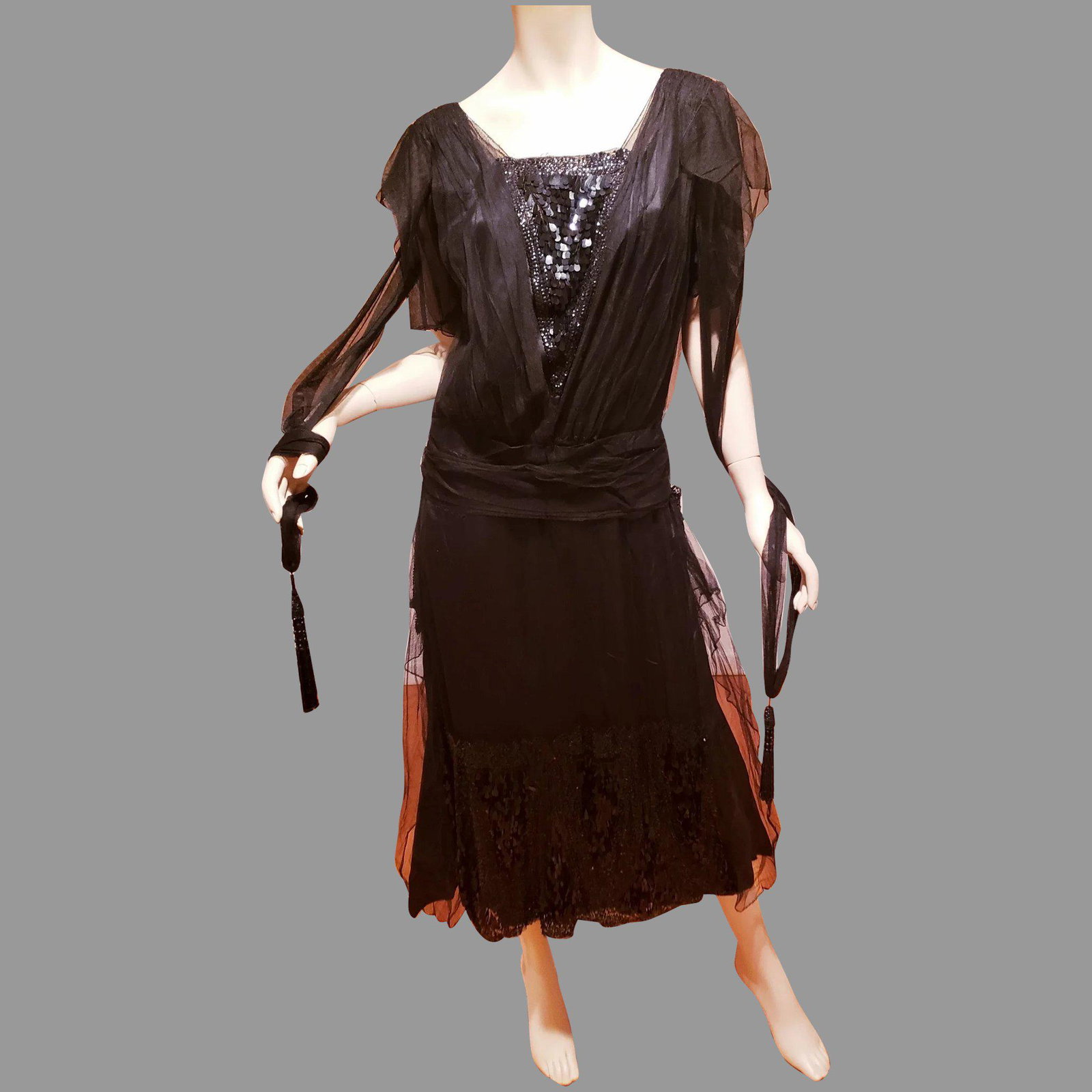 Antique 1920's Flapper dress Sequins on sheer netting: This dress is stunning . with panels of unusual oval tear sequins in black onyx. Sheer double net a silk with panels and drop Sash. Sheer sleeves wit opening and tie wings that hang down from shoulder
