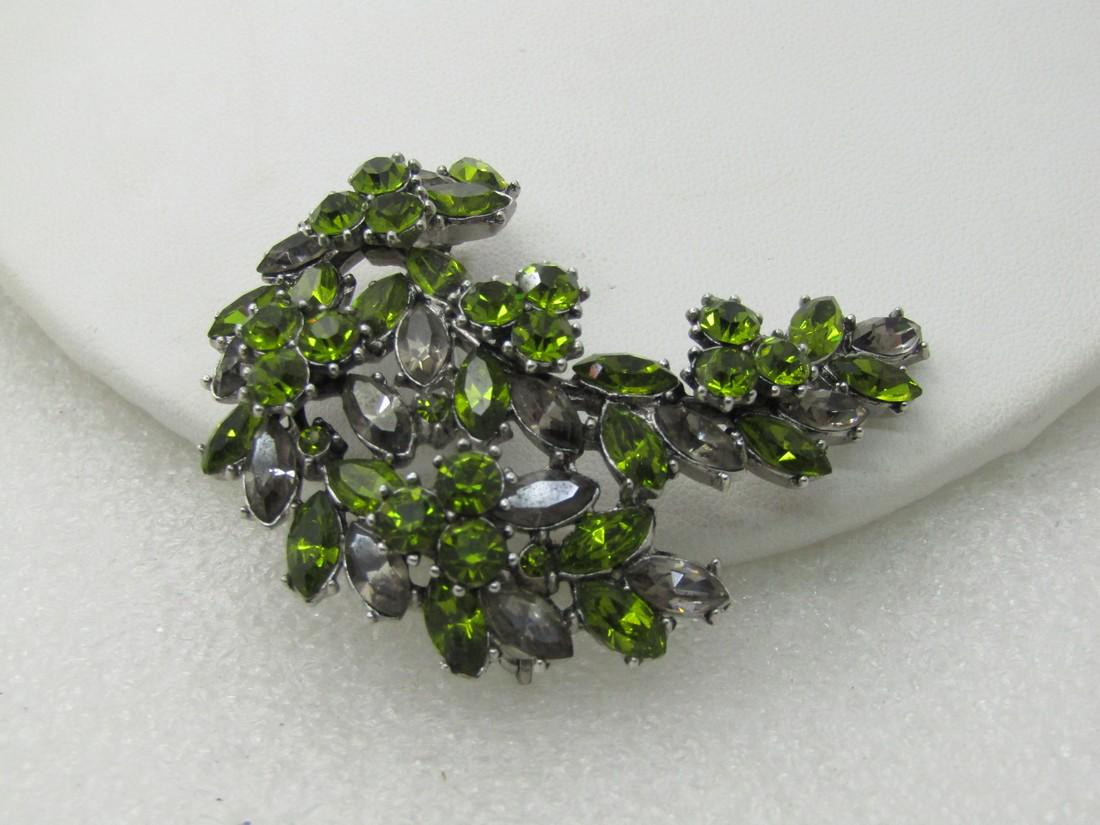 Vintage Crown Trifari Green Rhinestone Brooch, Art: Vintage Crown Trifari Green Rhinestone Brooch, Art Deco, 2.25" long and appx. 1.25" wide. Tiered design with a mix of round and marquise stones in green and smoky clear. Silver Tone. Very good conditi