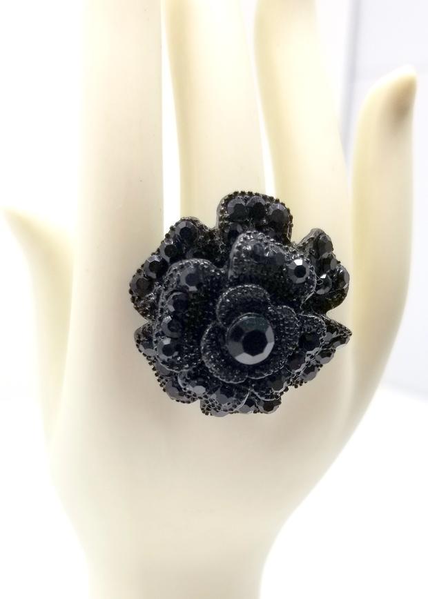 Black Bold Statement Crystal Flower Ring: We offer this Black Bold Statement Crystal Flower Ring in size 7. This bold ring offers black shining crystals reminiscent of marcasite in a variety of sizes and shapes. The band is black resin overla